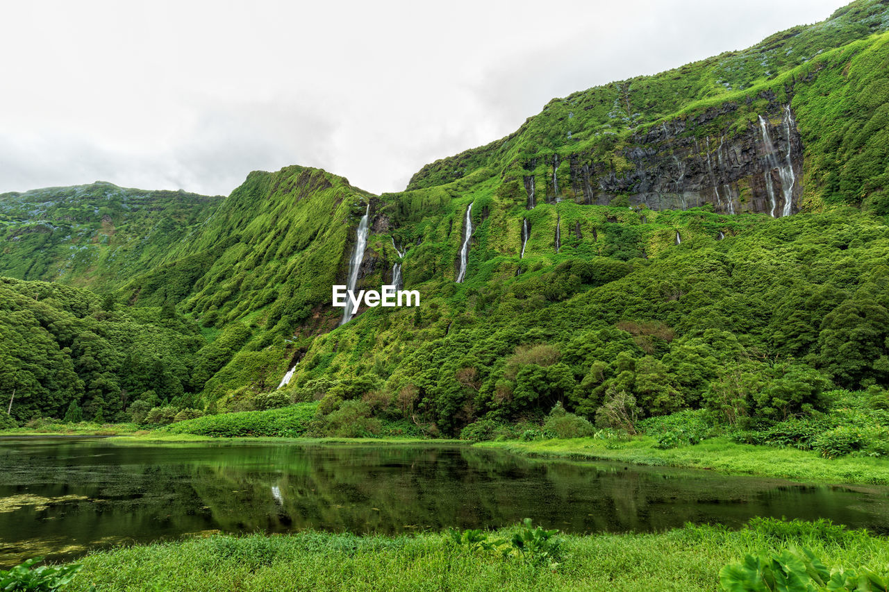 Scenic view of lake by mountain against sky