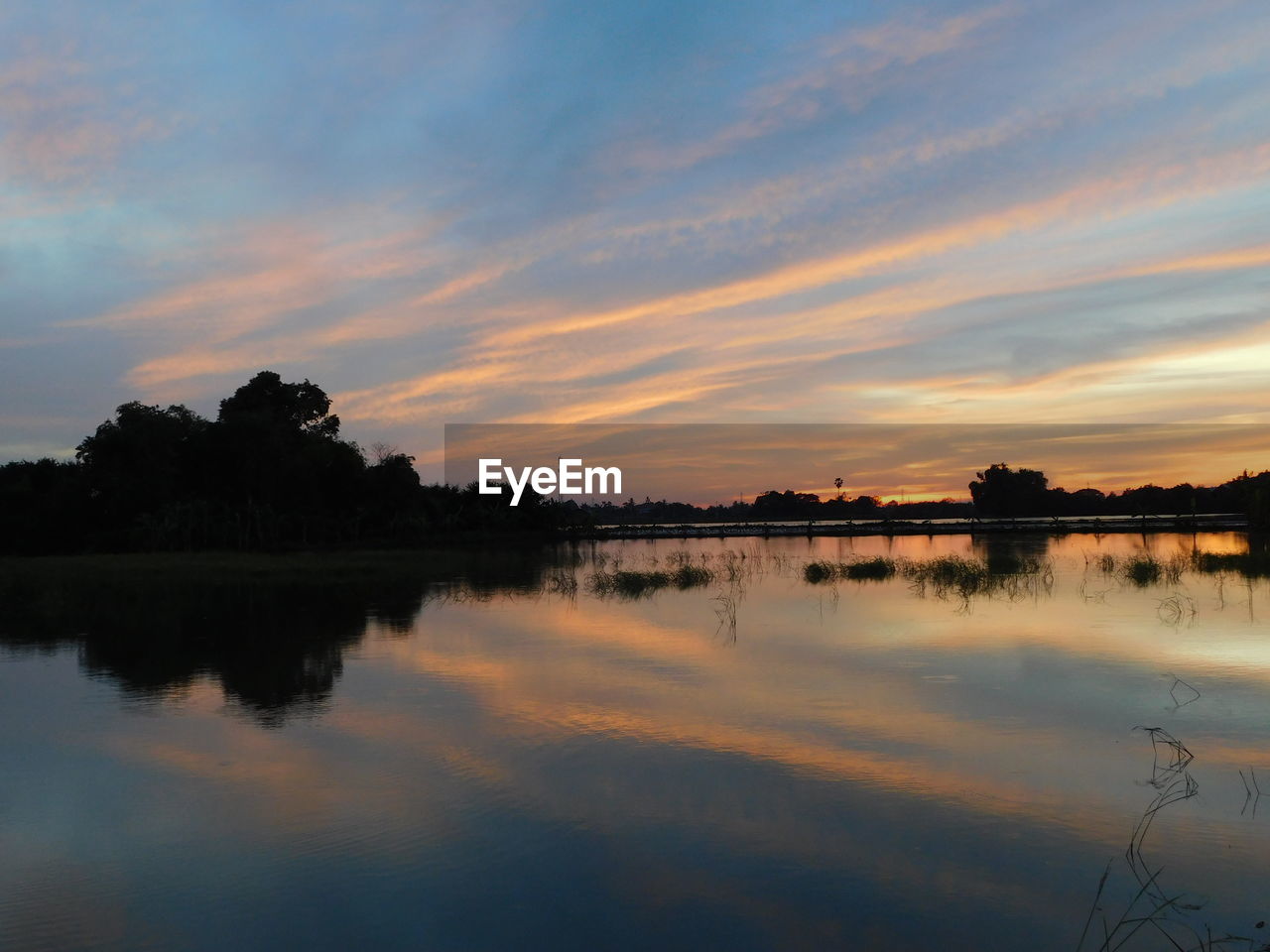 Scenic view of lake against sky during sunset