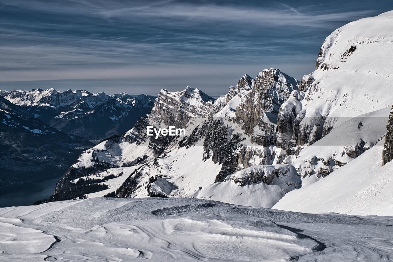 Scenic view of snow covered mountains against sky during winter