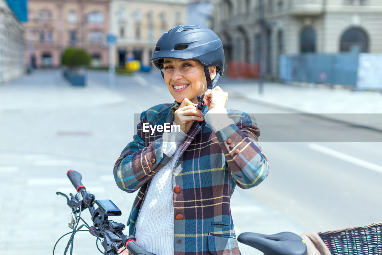 PORTRAIT OF HAPPY MAN RIDING BICYCLE ON CITY