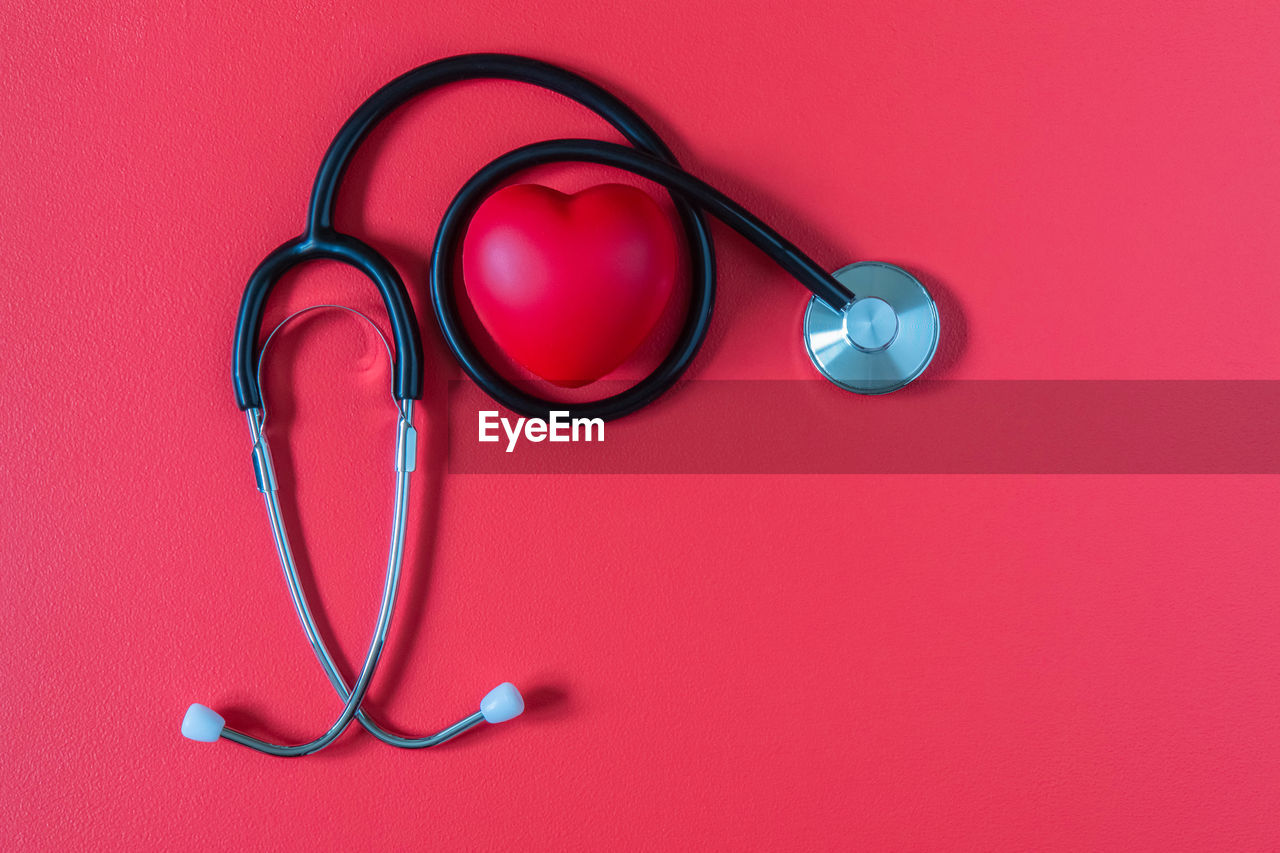 CLOSE-UP OF EYEGLASSES ON RED BACKGROUND