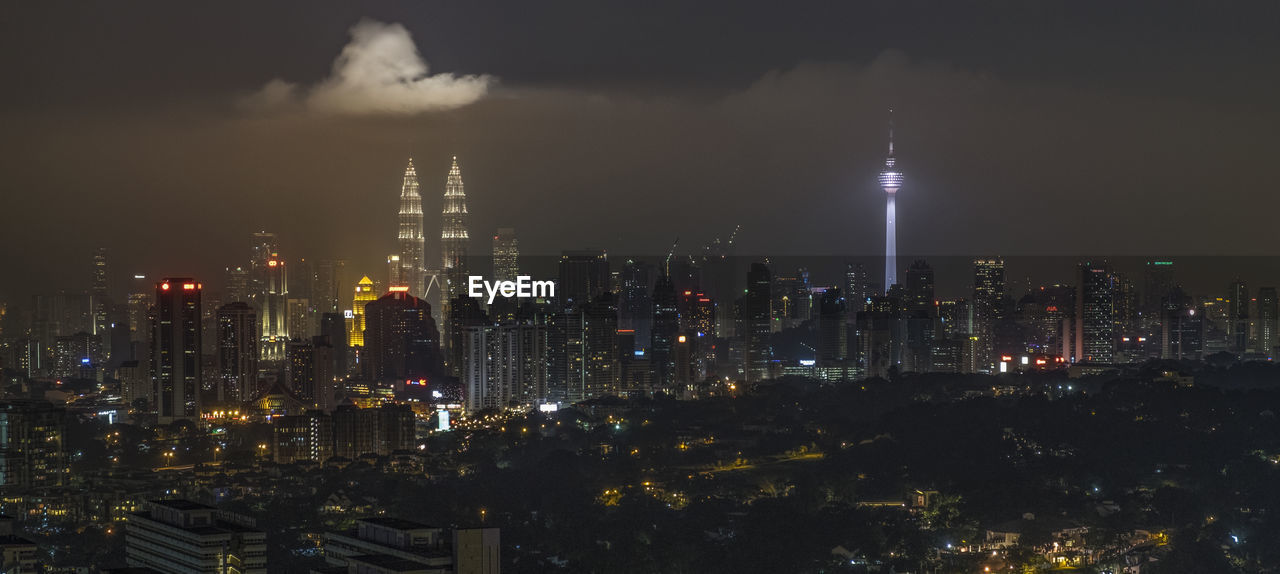 Illuminated city against sky at night