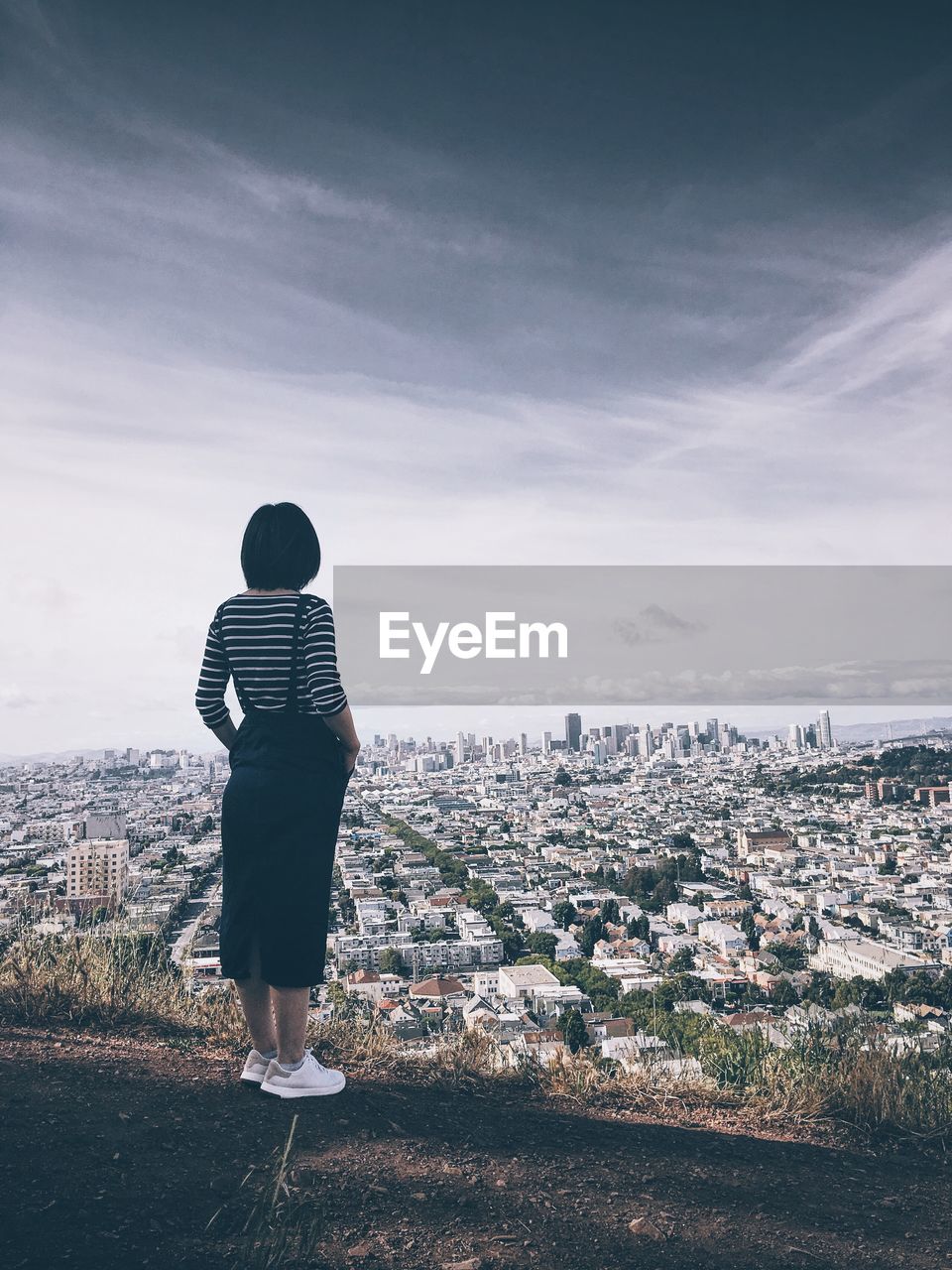 Woman standing over cityscape against sky