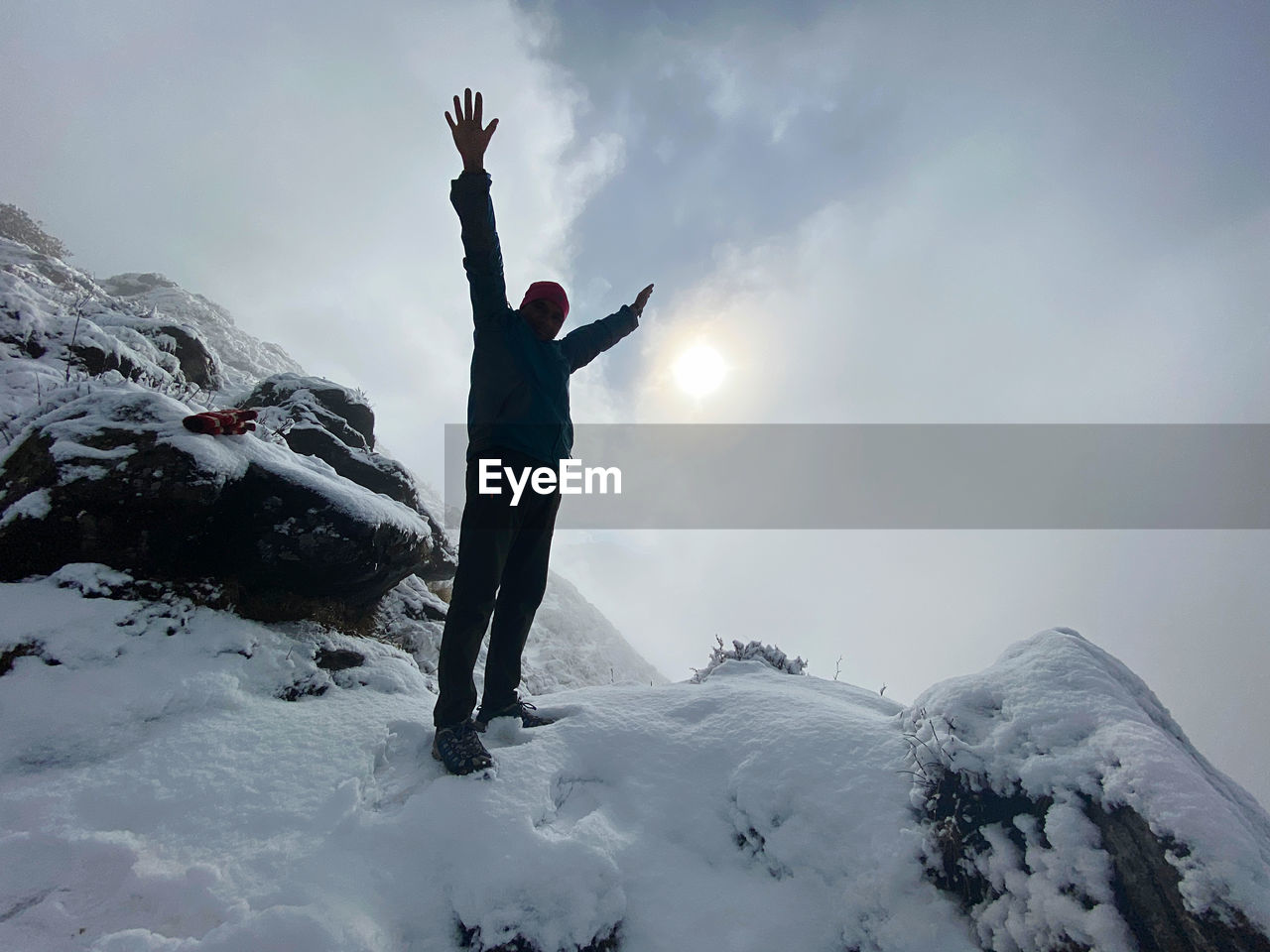 FULL LENGTH OF PERSON STANDING ON SNOWCAPPED MOUNTAIN
