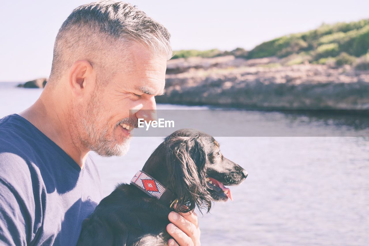 Smiling man with dog at beach