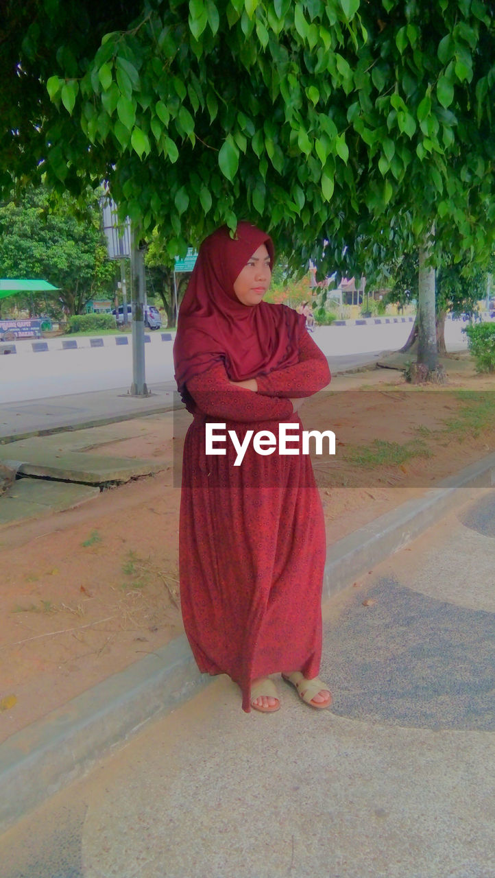 WOMAN STANDING ON FOOTPATH