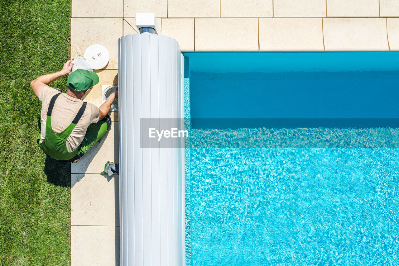 High angle view of man working by swimming pool