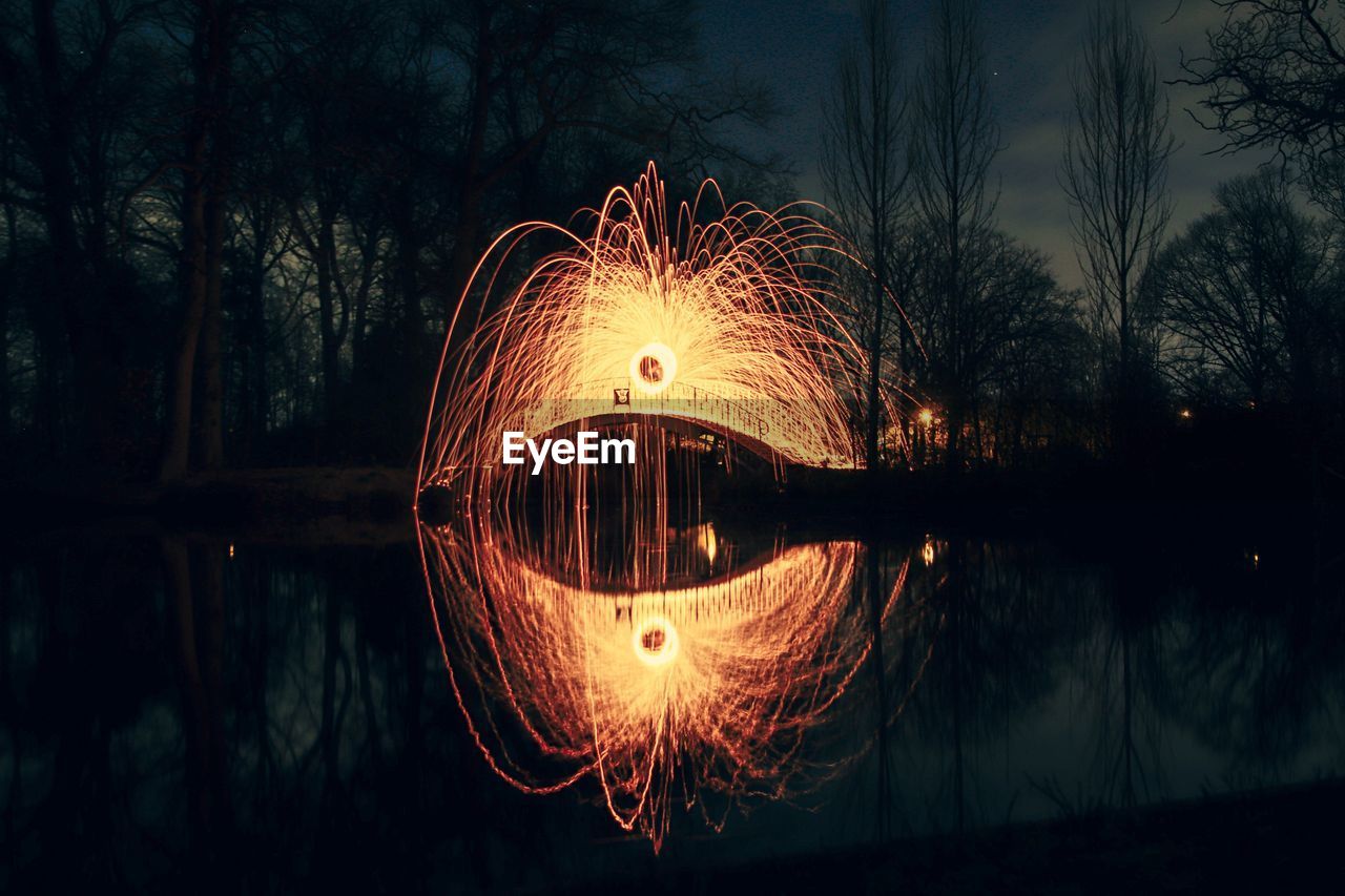 ILLUMINATED LIGHTING EQUIPMENT IN LAKE AT NIGHT