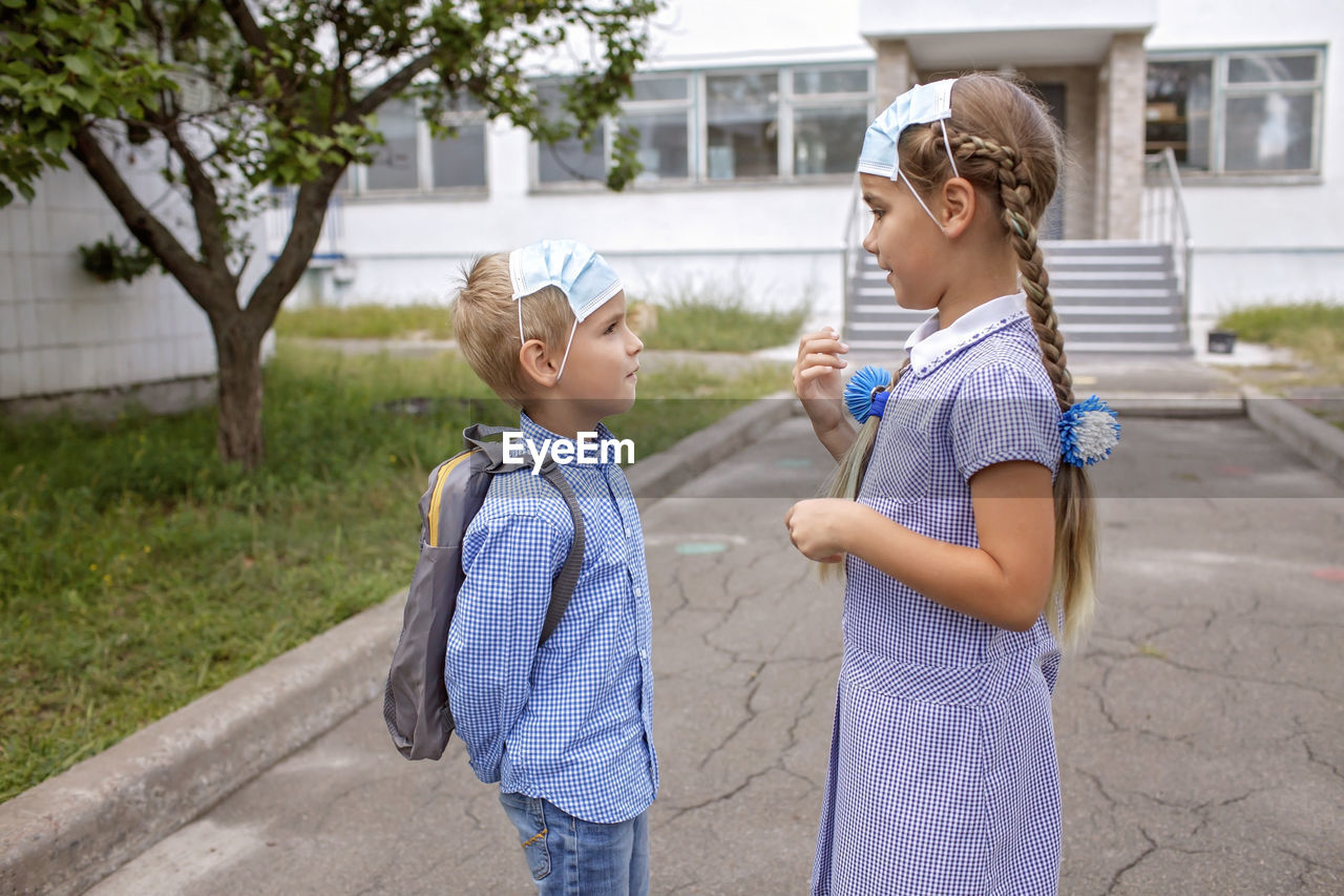 Side view of smiling girl standing outdoors