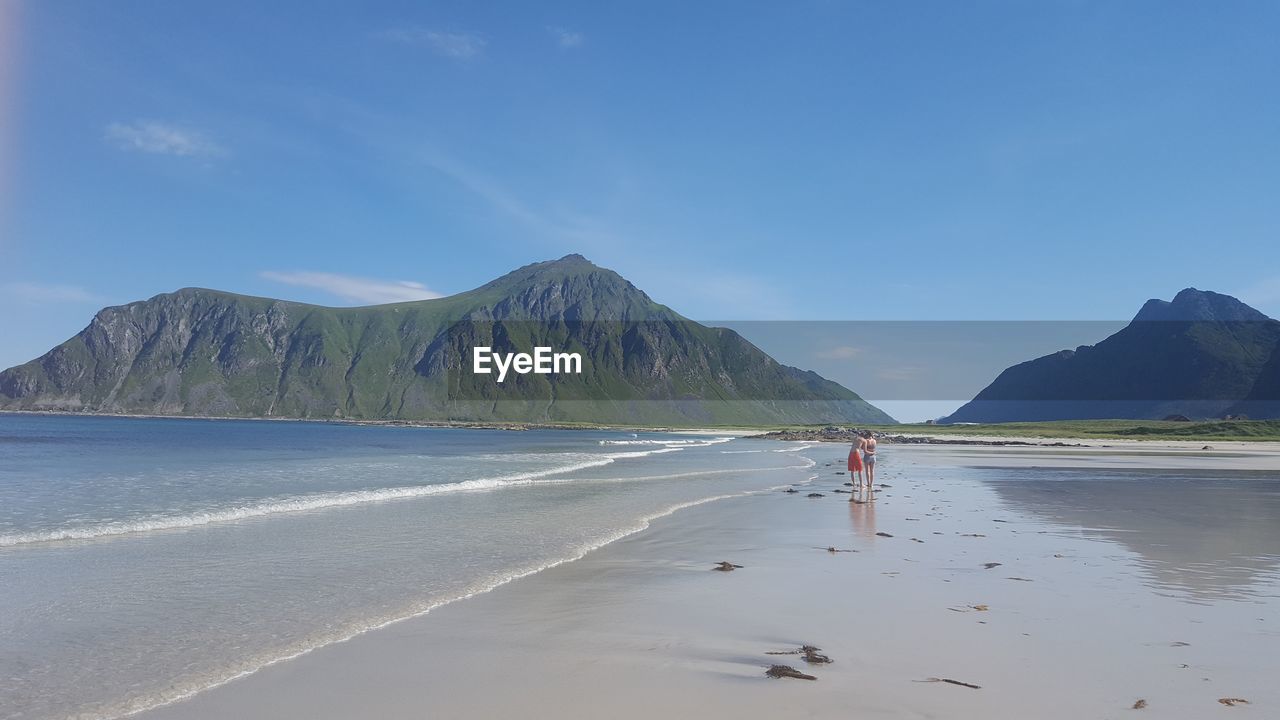 SCENIC VIEW OF BEACH AGAINST MOUNTAINS