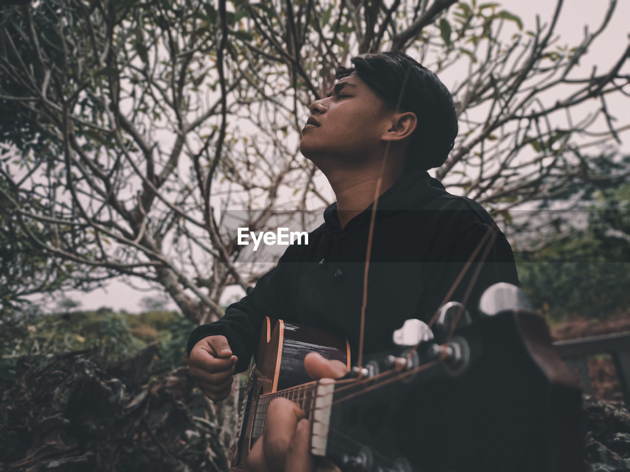 Close-up of man playing guitar outdoors