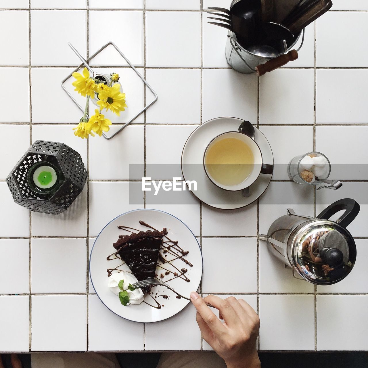 Cropped image of hand cutting pastry in plate on table