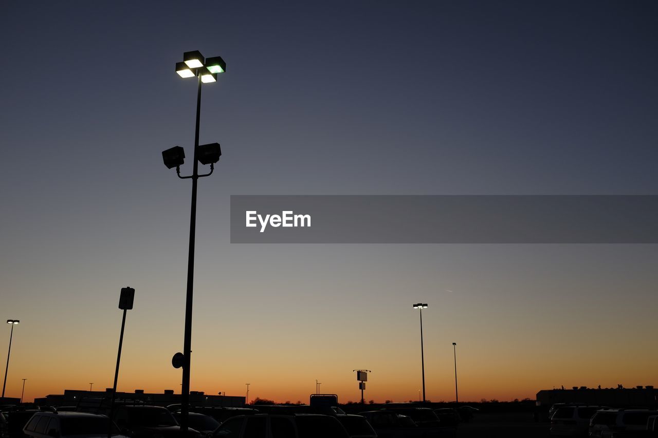 Low angle view of street lights against clear sky during sunset