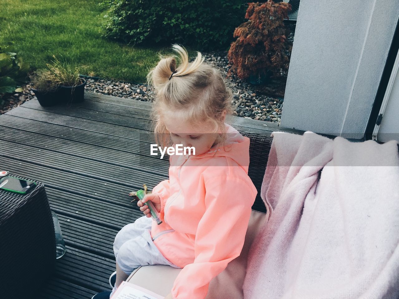 High angle view of girl sitting on sofa at yard