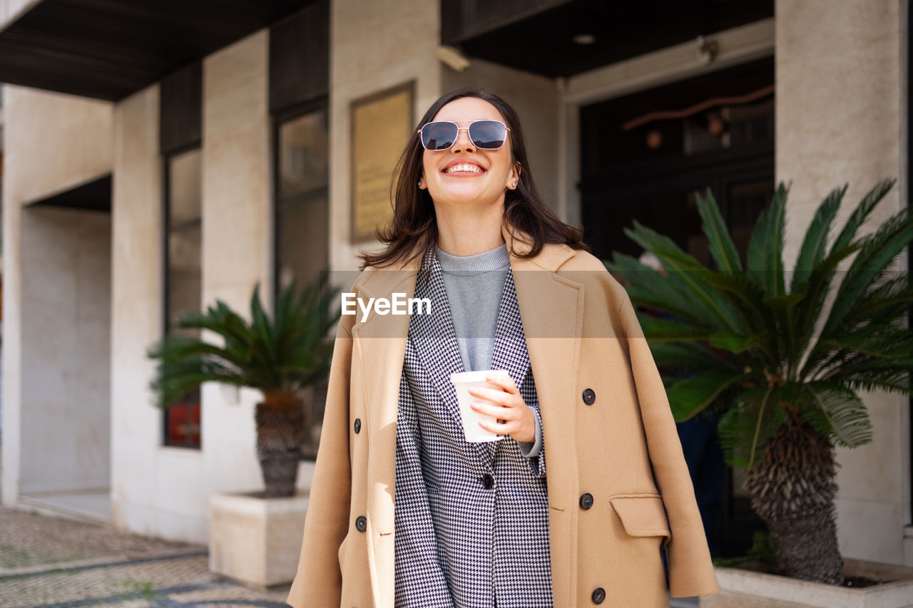 portrait of young woman wearing sunglasses while standing outdoors