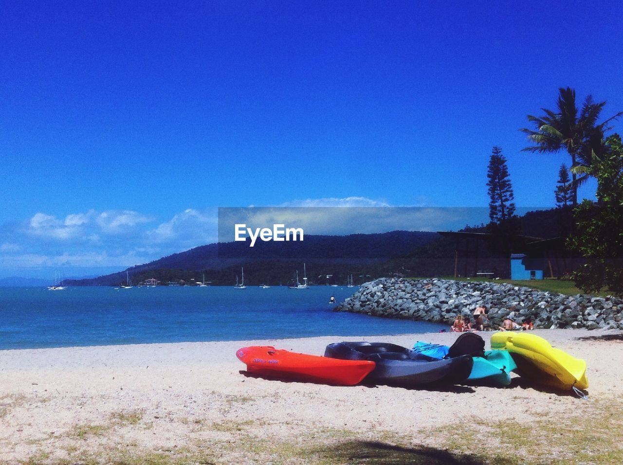 Boats on beach against blue sky