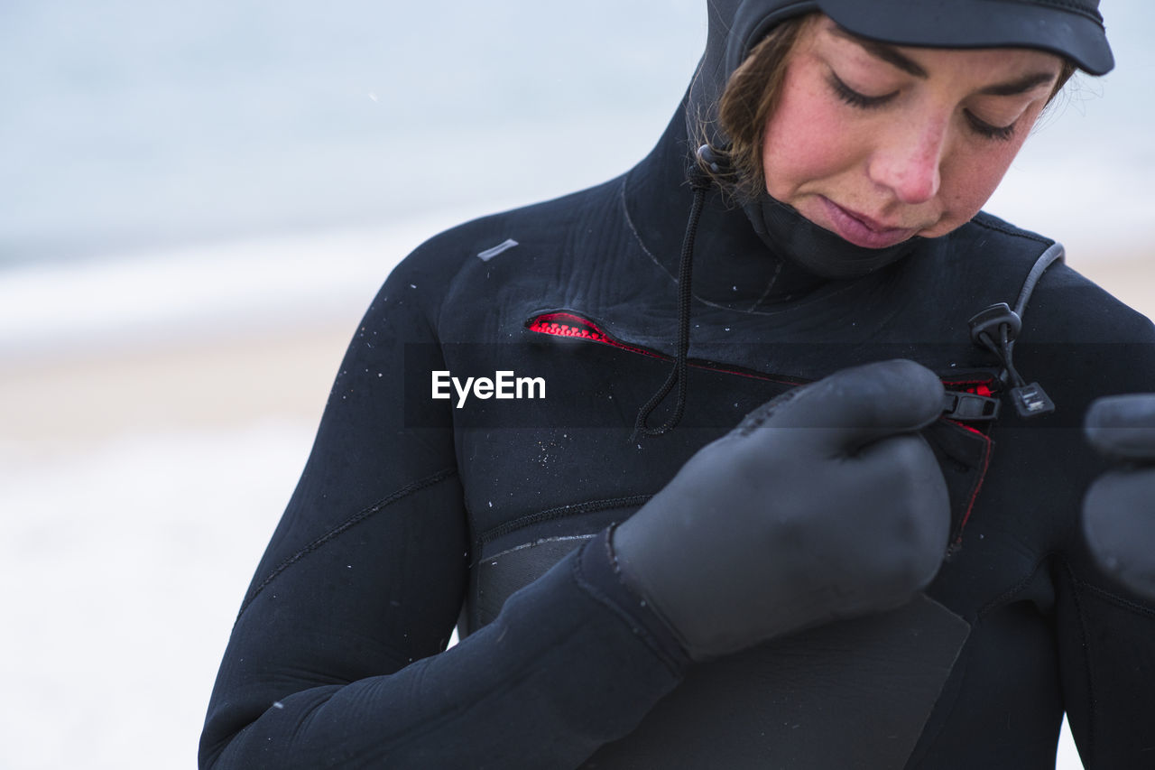 Young woman preparing to go winter surfing in snow