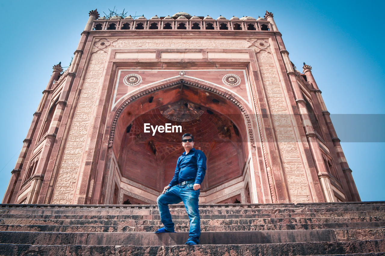 Low angle view of man standing against building