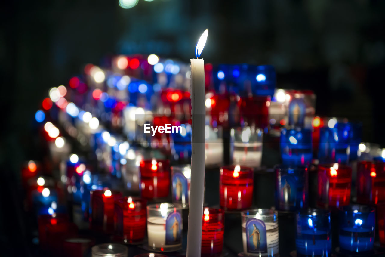 Close-up of illuminated candles in darkroom