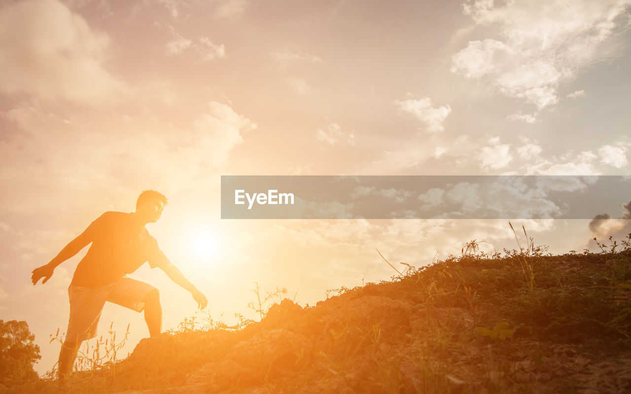 MAN ON ROCK DURING SUNSET