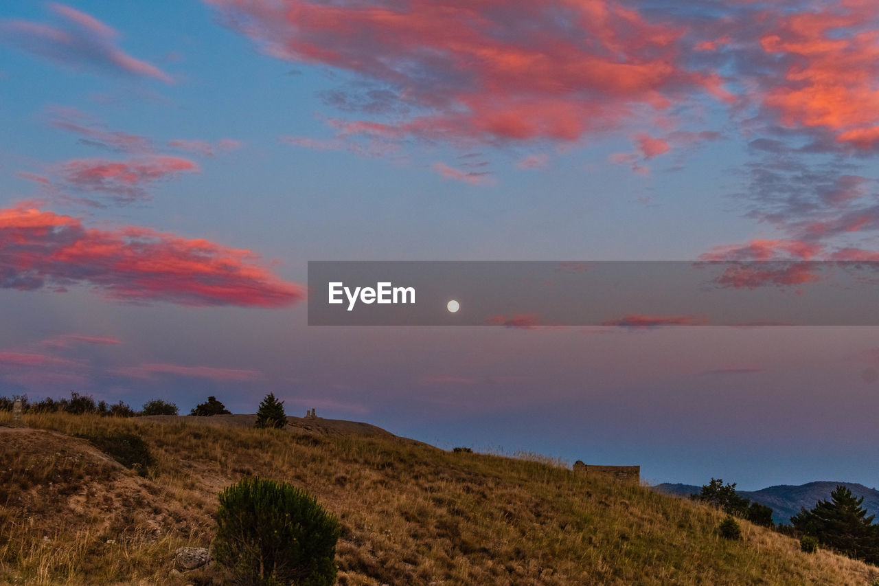 Scenic view of field against sky at sunset