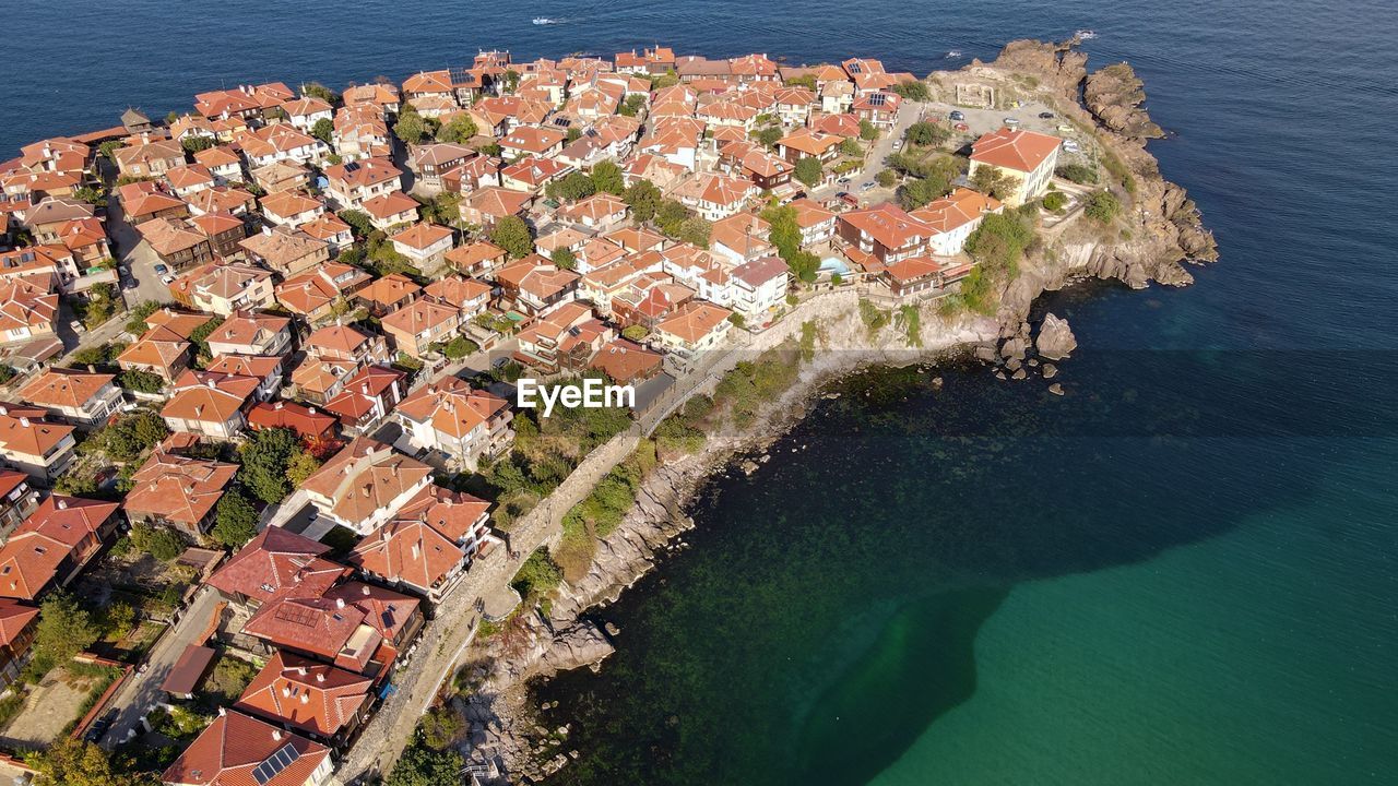 HIGH ANGLE VIEW OF TOWNSCAPE AND SEA BY CITY