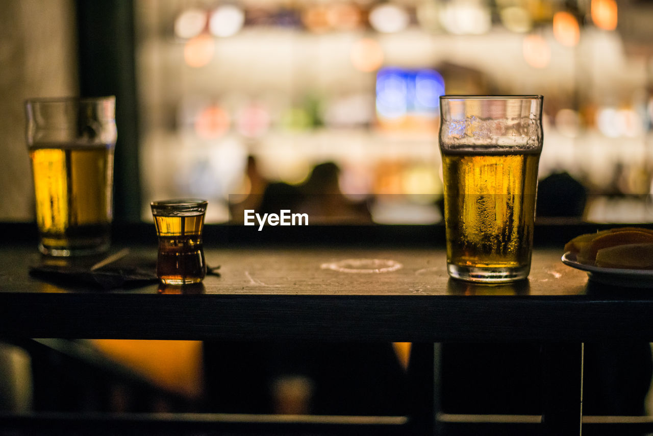 Close-up of beer glasses on table