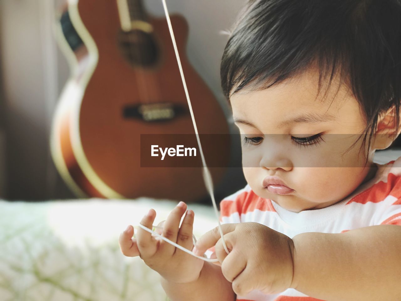 Close-up of cute boy playing with string at home