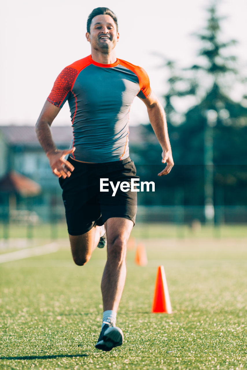 Full length of man running on grassy field