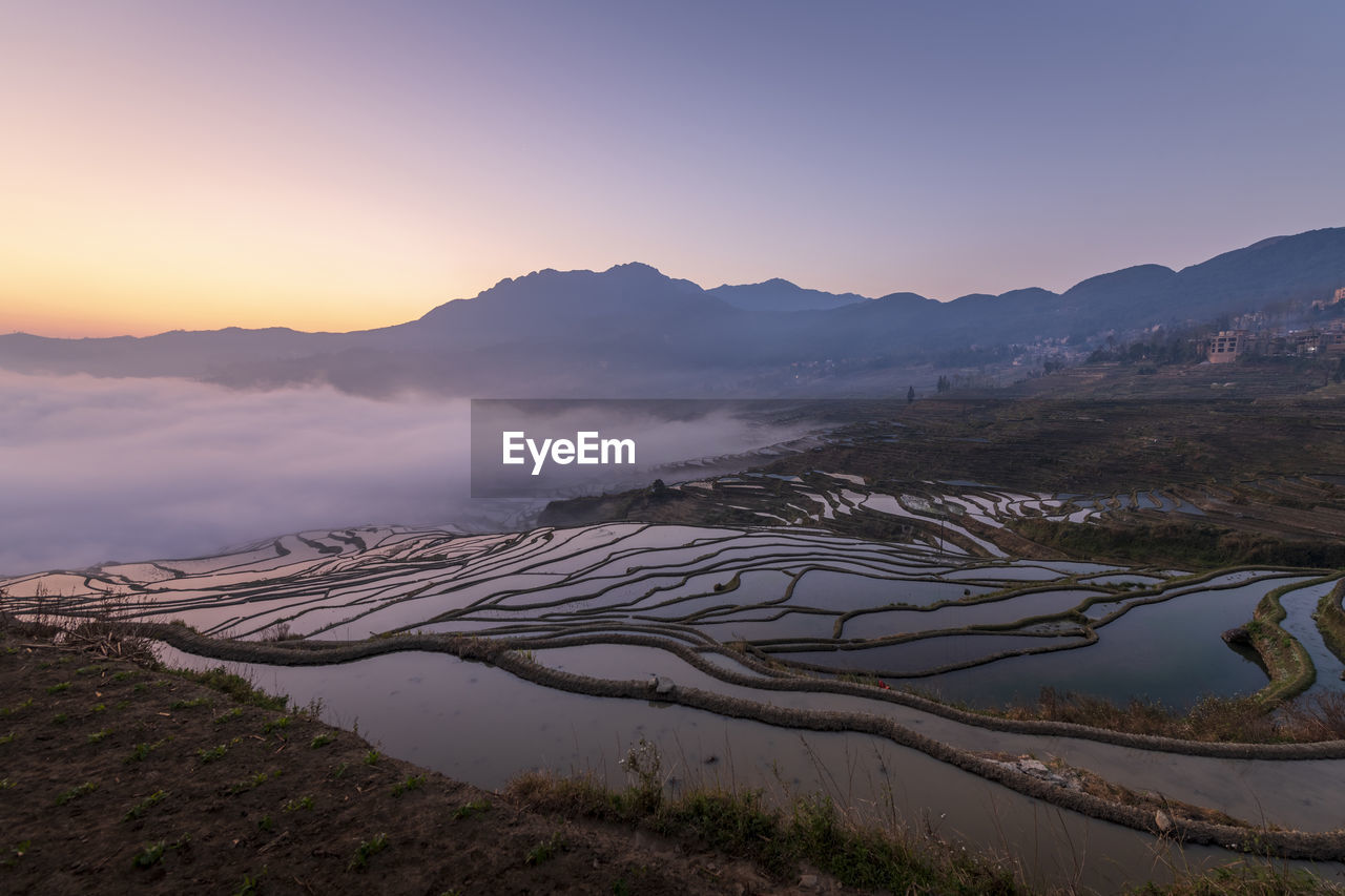 SCENIC VIEW OF AGRICULTURAL FIELD AGAINST SKY DURING SUNSET