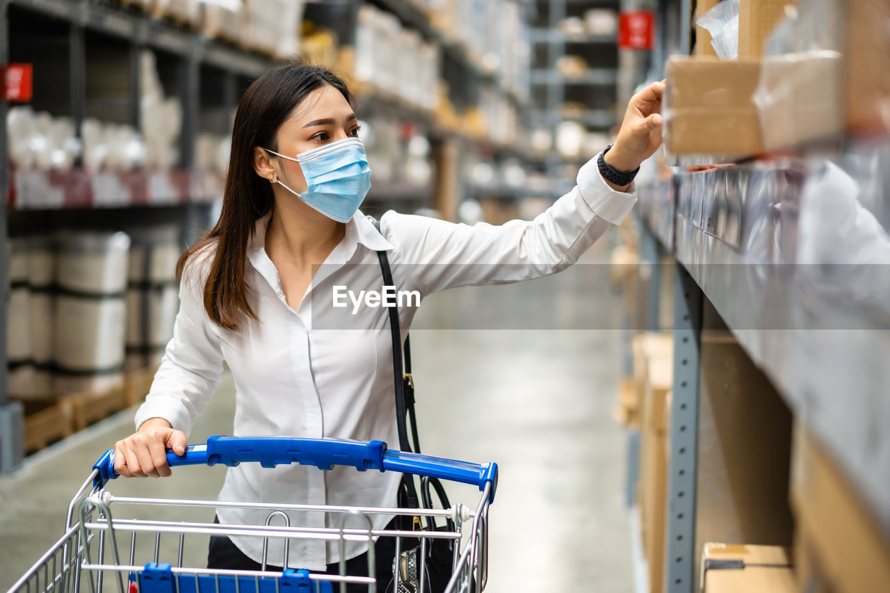 WOMAN WITH UMBRELLA STANDING AT STORE