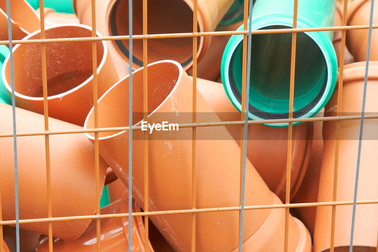 Full frame shot of multi colored pipes seen through metal grate