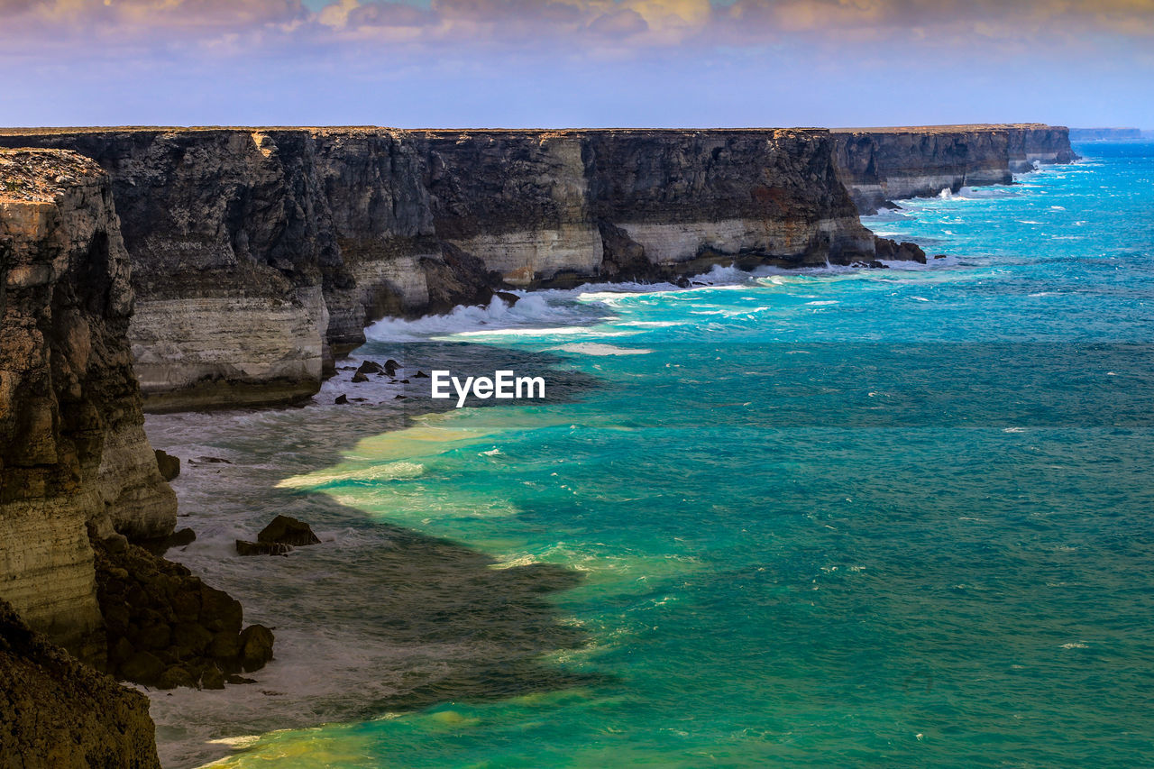 SCENIC VIEW OF SEA BY ROCK FORMATION AGAINST SKY