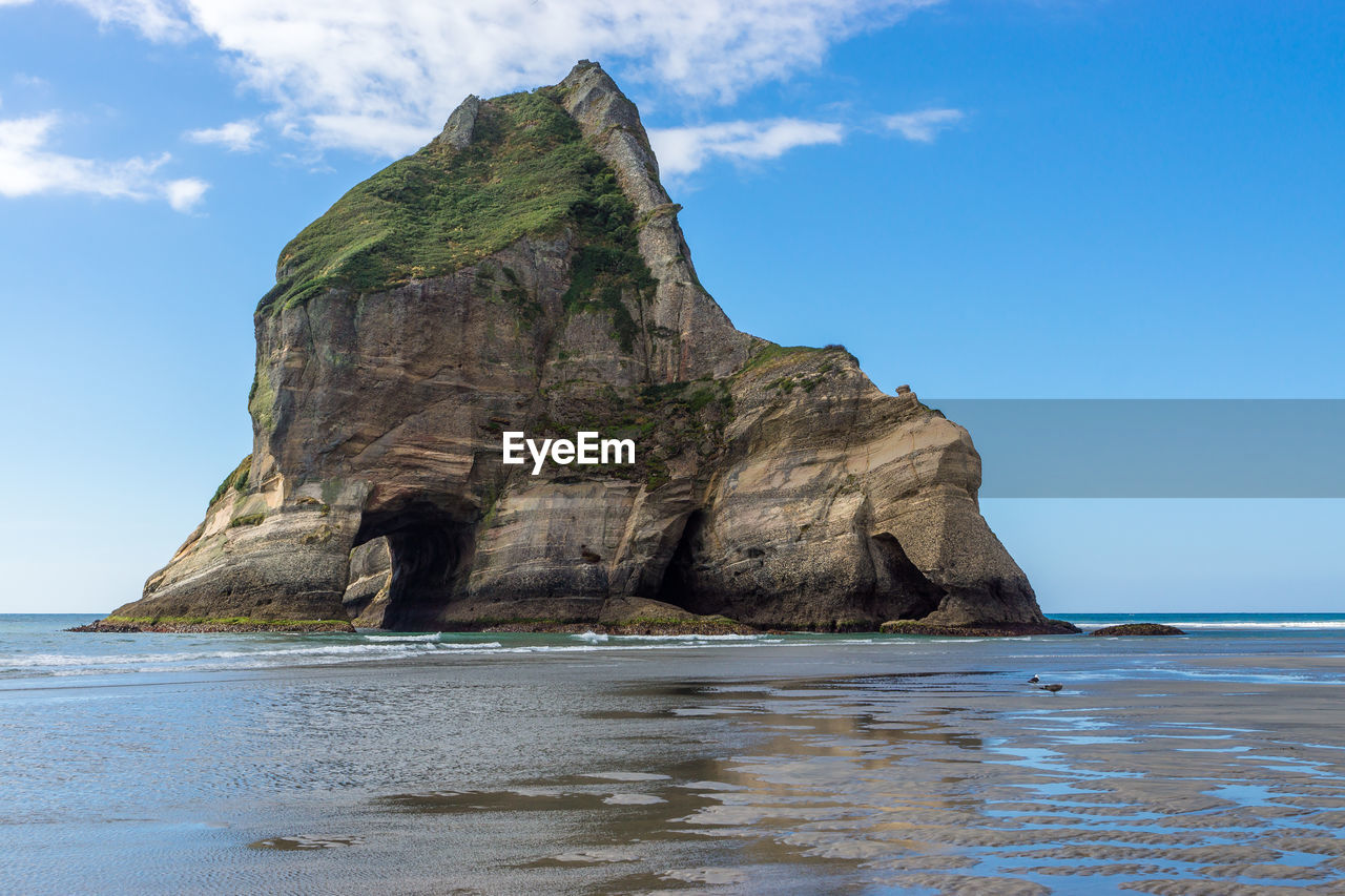 Rock formation on sea against sky