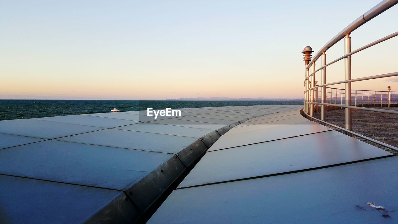 Scenic view of shore and sea against sky during sunset