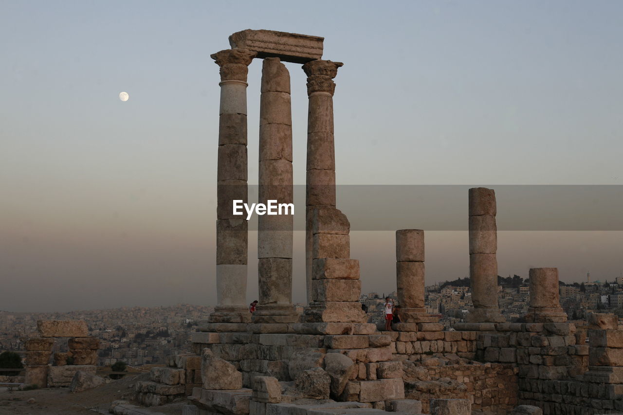 Low angle view of amman citadel seen from cave against sky during sunset