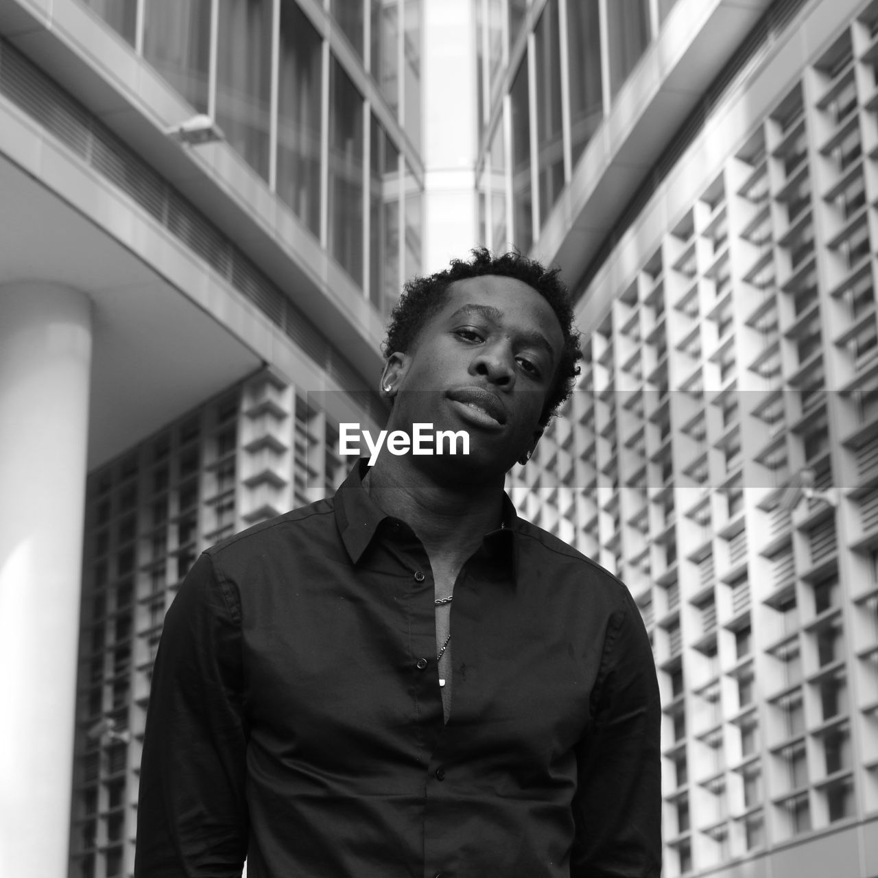 Low angle view of young man looking away against building