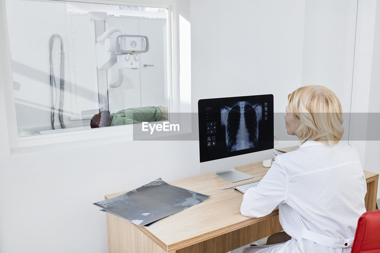 Radiologist taking x-ray shot of patient in clinic