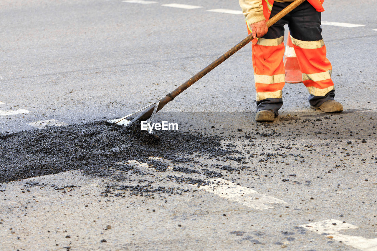 Low section of construction worker working on road