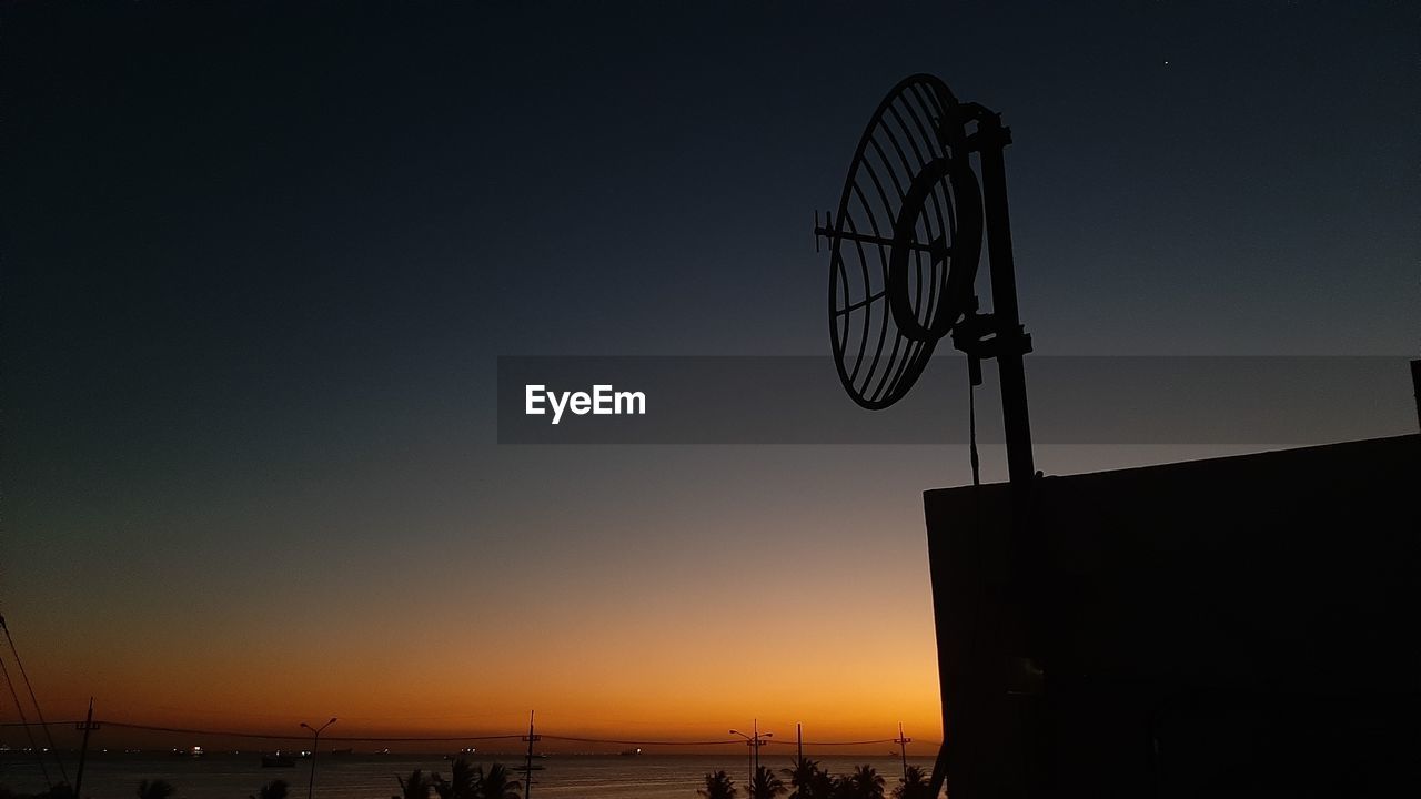 LOW ANGLE VIEW OF SILHOUETTE BUILDING AGAINST CLEAR SKY AT SUNSET