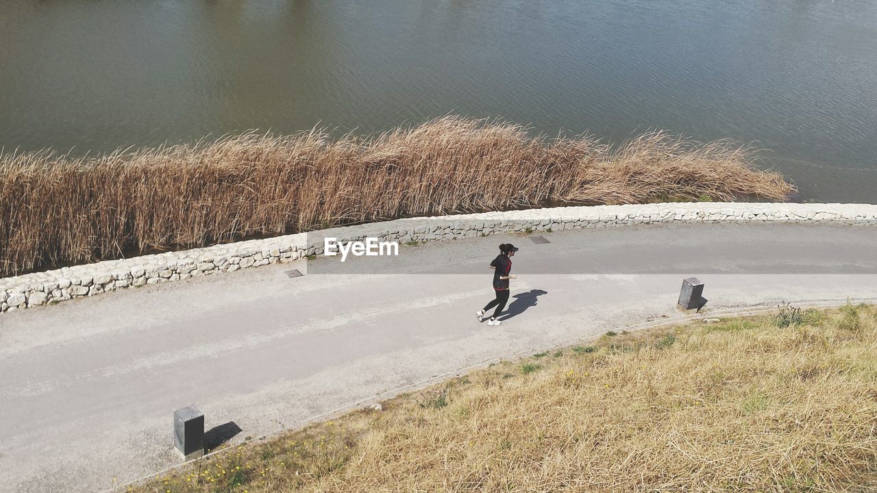 High angle view of woman jogging on road