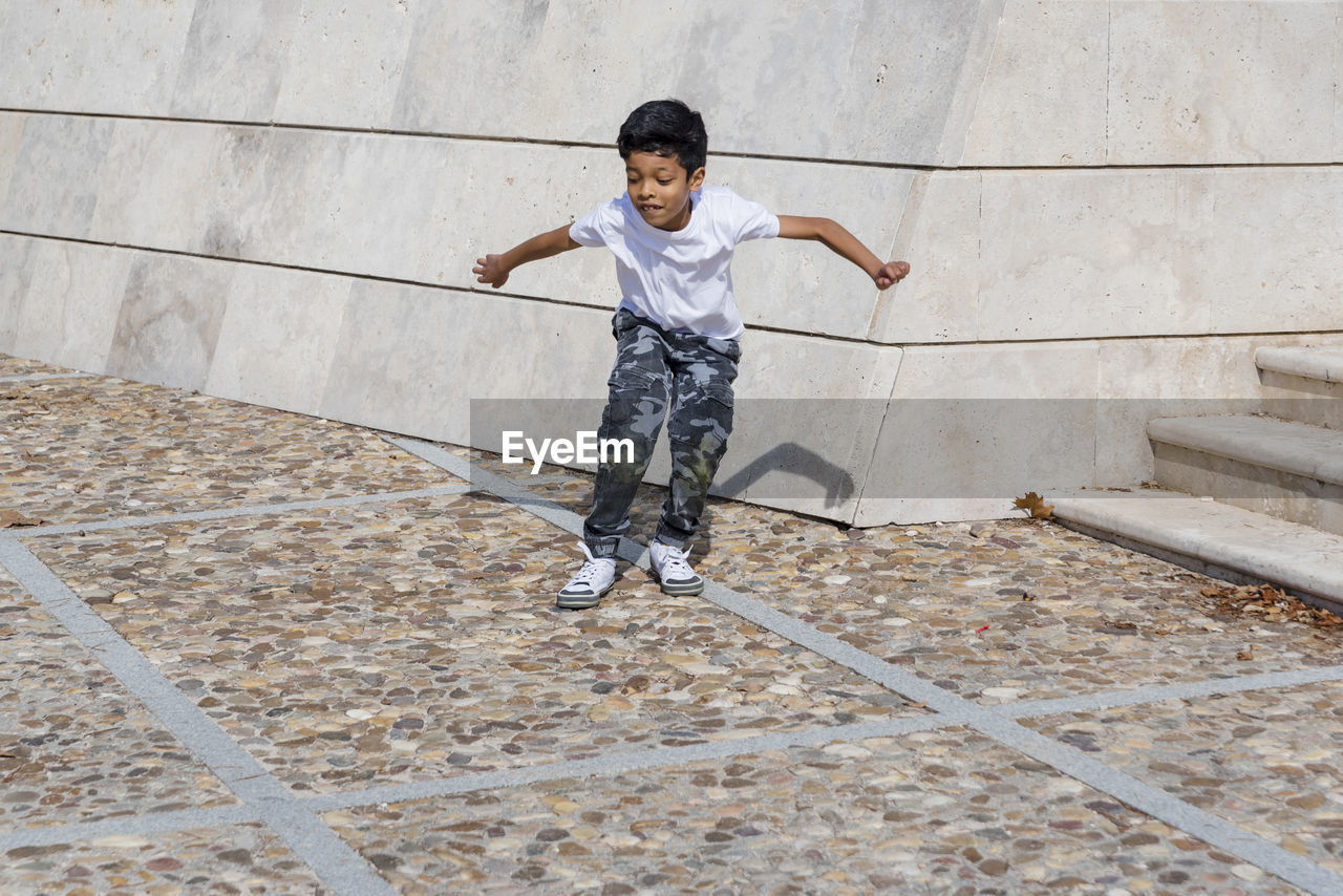 Young boy jumping while having fun in a park.