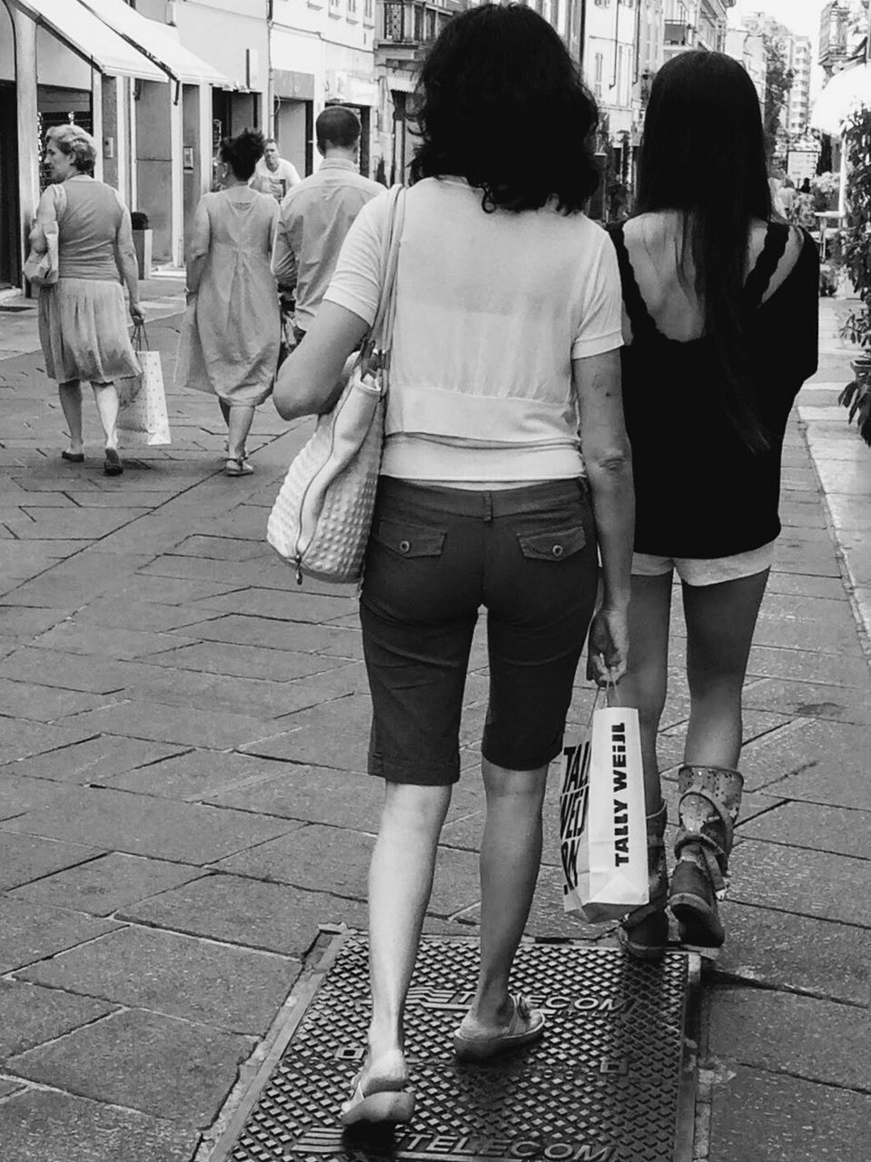 REAR VIEW OF WOMAN WITH UMBRELLA ON ROAD