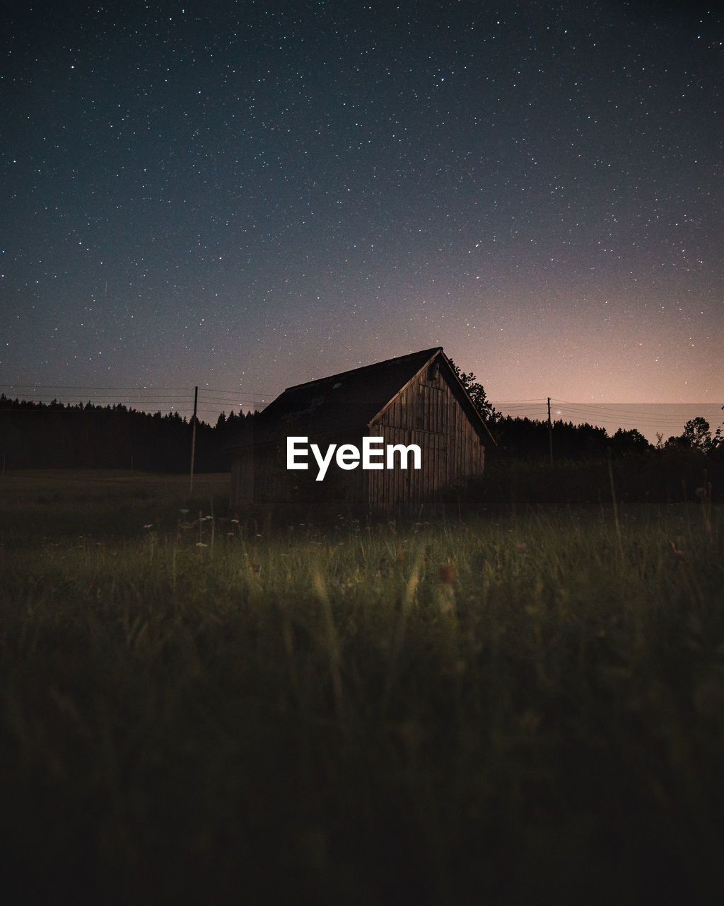 House on field against sky at night