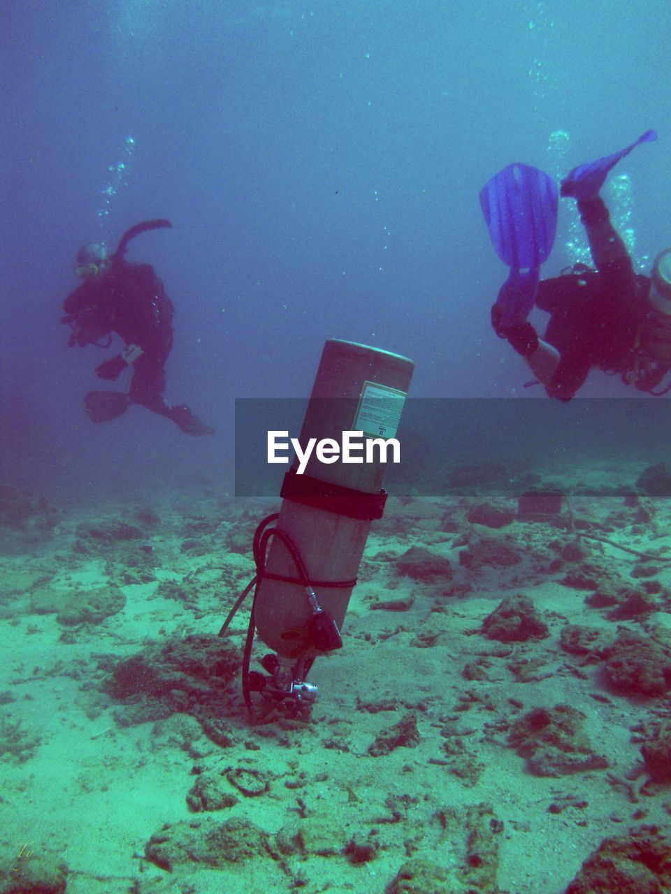 Underwater view of scuba tank and divers