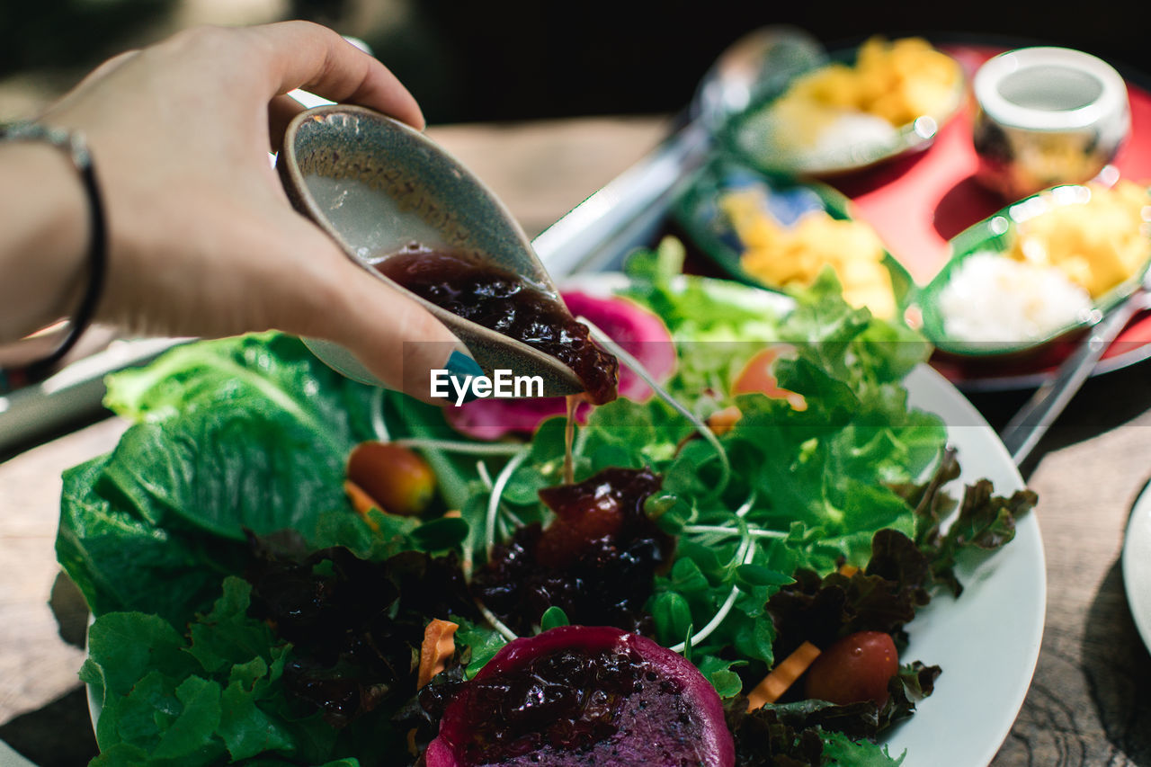 Close-up of hand holding vegetables on table