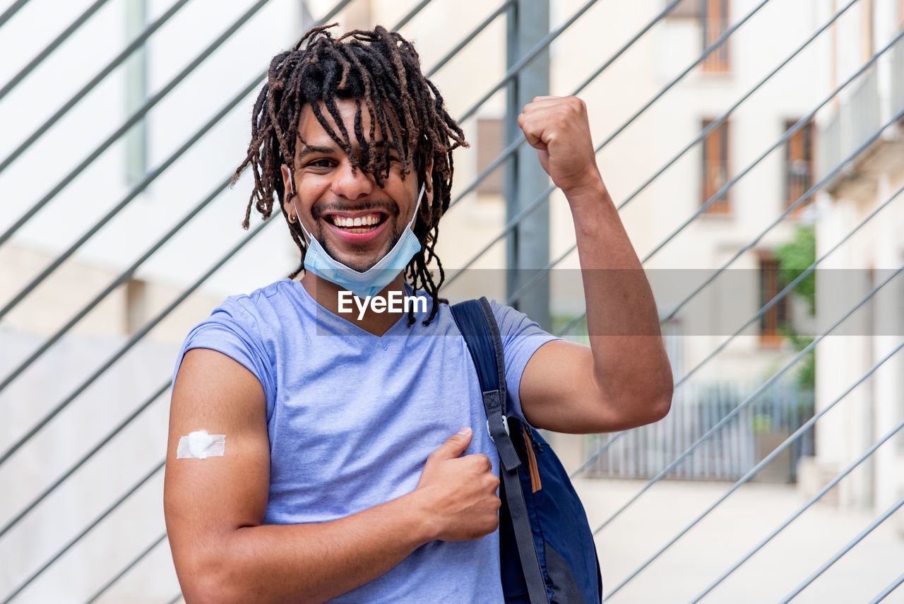 Young latin man vaccinated showing his arm