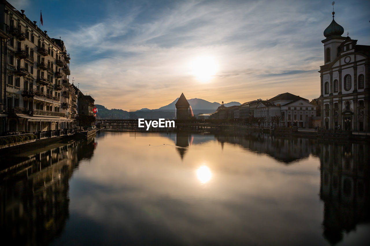 Sunrise in lucerne, switzerland, the city center, river and chapel bridge against blue sky.