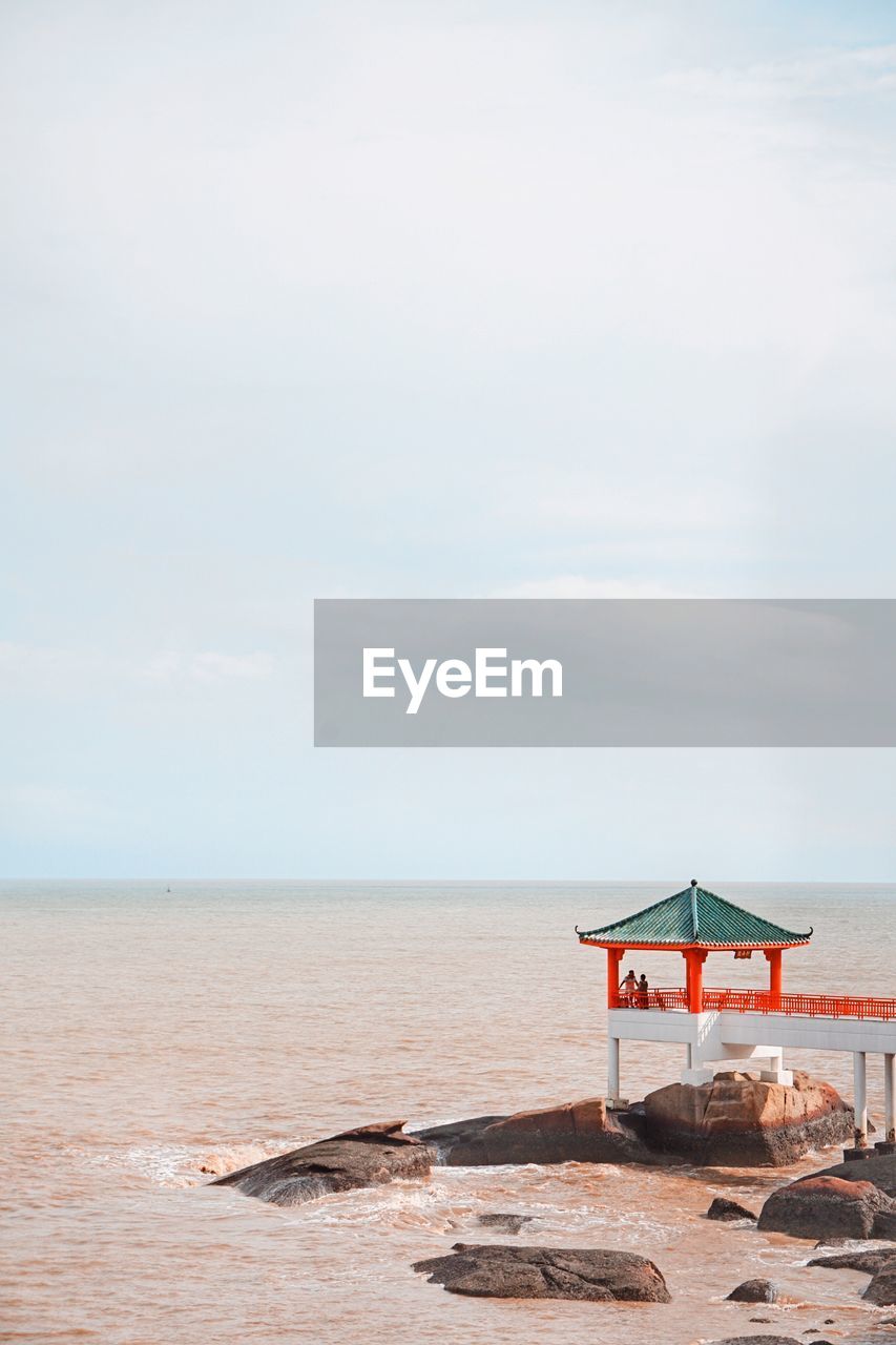 Pier at beach against sky