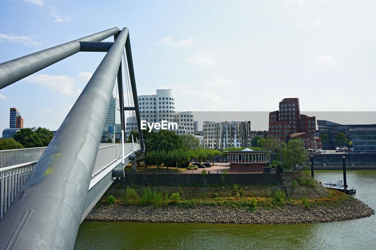 BRIDGE OVER RIVER AGAINST BUILDINGS IN CITY